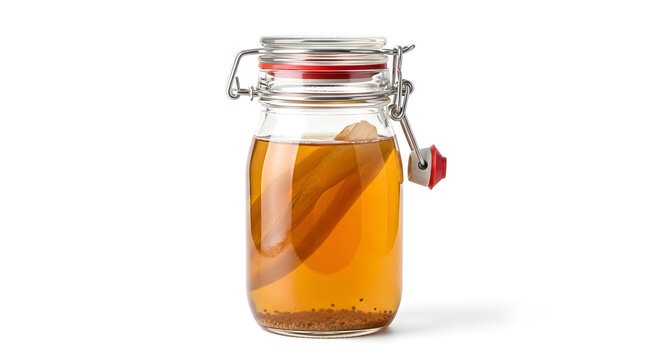 A glass jar filled with a fermented tea drink and a SCOBY