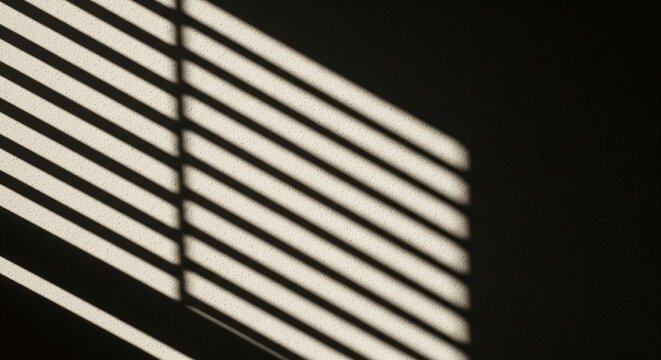 Minimalist composition showing geometric shadows and light patterns cast by window blinds on a dark wall.