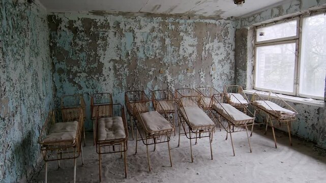 Empty rusty cots inside a derelict hospital room in the Chernobyl Exclusion Zone