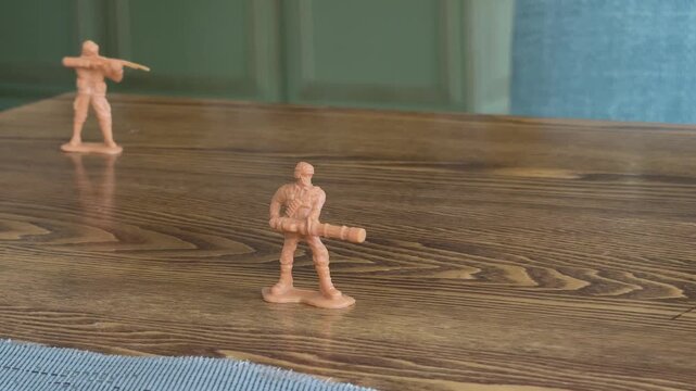 Close view of toy soldiers arranged on wooden table creating miniature battle scene. Symbol of strategy, conflict, game and imagination. Useful for war concept visuals, strategy content, storytelling