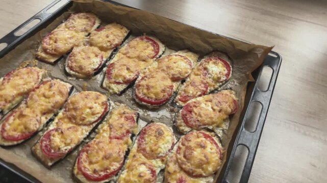 Baked Stuffed Eggplant Slices On Tray, Golden Melted Cheese And Tomato Topping Over Breadcrumb Filling,