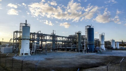 Obraz premium Industrial facility with storage tanks and pipelines under blue sky