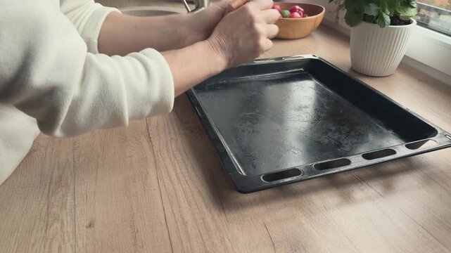 Hands crumple parchment paper before placing it on baking tray so it fits better and stops curling. Useful for cooking tutorials kitchen hacks baking lessons and practical home routine content.