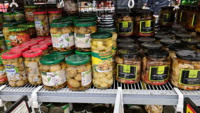 Pickled mushrooms in jars on supermarket shelf