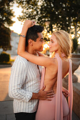 Fototapeta premium Romantic sunset embrace between a couple in a serene park