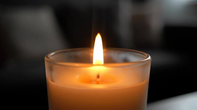Candle flame in glass jar with wax, soft warm light close up for quiet luxury daily routine, home interior relaxation, mindfulness, cozy atmosphere