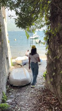 Rear View Woman Walking in Charming Streets of Lake Como, Italy, Scenic Travel Lifestyle with Beautiful Lake Views and European Architecture