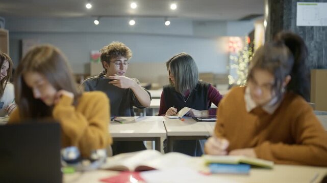 Diverse students study, collaborate, and share lighthearted moments in a modern classroom or library. Young people are engaged in learning activities and enjoying their time together.