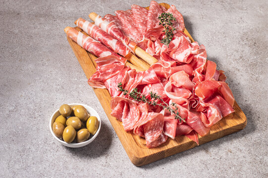 Charcuterie board. Antipasti appetizers of meat platter with salami, prosciutto crudo or jamon and olives.
