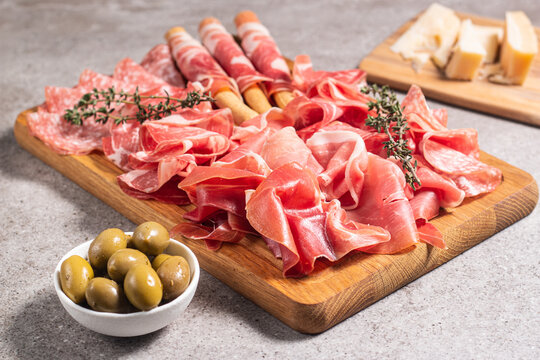 Charcuterie board. Antipasti appetizers of meat platter with salami, prosciutto crudo or jamon and olives.