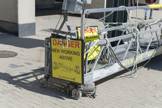 Wildcats Building Services signs on a motorized swing stage in Toronto