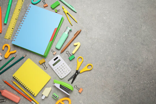 Composition with notebooks and school stationery on grey grunge background
