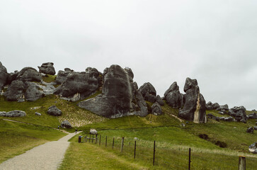 Wide view of limestone rock formations and mountain ridge under low clouds at Castle Hill Kura Tawhiti Conservation Area, Canterbury Region, New Zealand © apiwit
