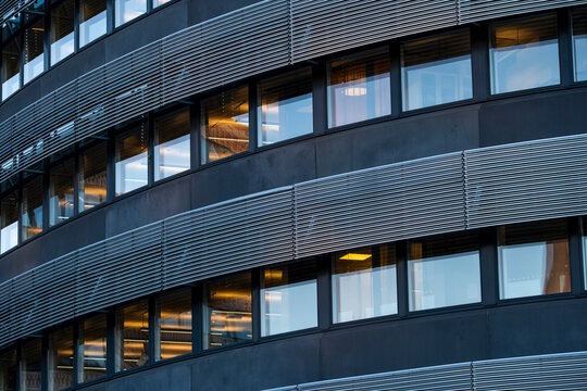 Symmetry pattern in modern office windows as lines and bands wrap the architecture building facade creating calm corporate rhythm and structure