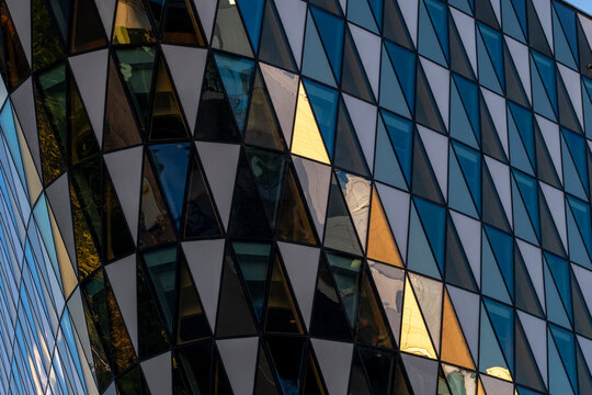 Modern architecture building facade with glass windows shows geometry triangles in abstract pattern suggesting innovative materials and urban identity