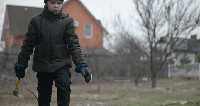 Men with kid cut branches in backyard and stockpile firewood in shed for winter. 4K 10-bit