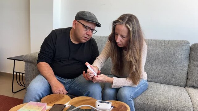 Mujer haciendo prueba de glucosa a su marido en casa