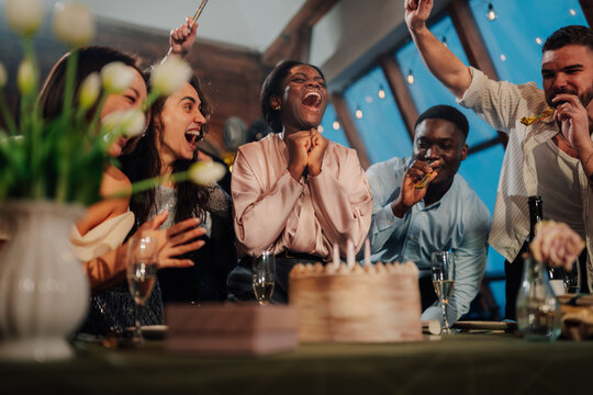 Group of diverse friends gathering for a birthday celebration, sharing joy, laughter, and happiness at an intimate party