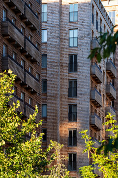 Residential brick apartment building architecture in Sweden with autumn trees beside urban Stockholm street showing textured facade and height