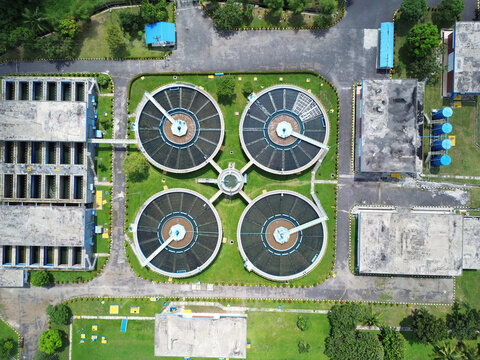 Radial clarifiers at wastewater processing plant showing environmental infrastructure from above aerial