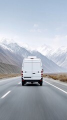 Obraz premium White van driving on highway toward snow capped mountain range