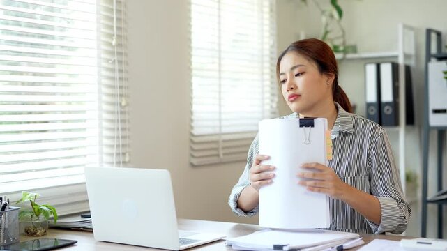 Businesswoman searching for papers document at desk in home office.