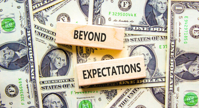 Beyond expectations words symbol. Concept words Beyond expectations on beautiful wooden blocks. Beautiful dollar bills background. Dollar bills. Business Beyond expectations words concept. Copy space.