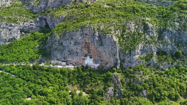 Aerial drone view of Ostrog Monastery in Montenegro. Orthodox Christian monastery built into a vertical rock cliff, famous pilgrimage site.