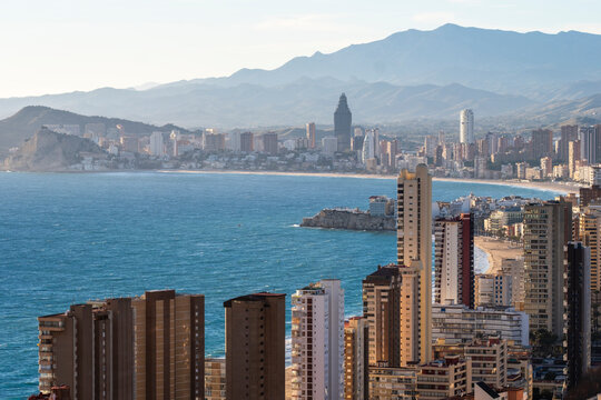 Daylight urban skyline showing highrise buildings along the sea coast with mountains behind Benidorm Spain residential property market