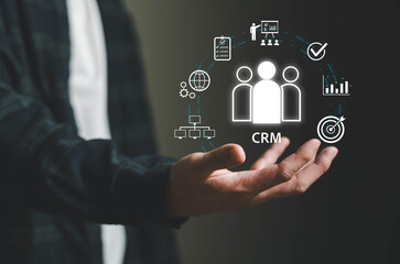 Obraz premium Hand presenting Customer Relationship Management concept with digital icons for analytics, sales, marketing, and customer data, representing business strategy, customer engagement, and data-driven.