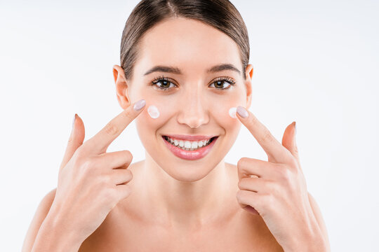 Attractive young woman applying cream on skin isolated on white background, skincare treatment, moisturizing lotion, hydration, beauty care and wellness concept