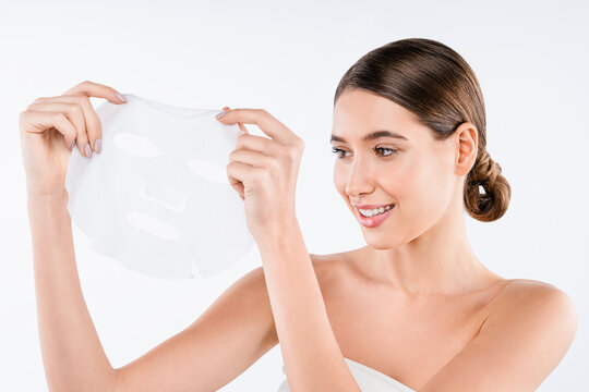 Beautiful young woman with sheet face mask isolated on white background, skincare routine, cosmetic treatment, hydration care and spa wellness concept