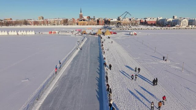 Lulea, Sweden - 24 February, 2026: Aerial view of the Sea Ice Marathon, a vibrant spectacle against the stark white expanse of the frozen sea, under a clear blue sky.