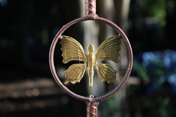 Sculpture de papillon doré en métal en extérieur  © Bovek Photography