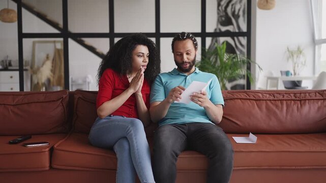 Young couple reading letter and celebrating citizenship application approval
