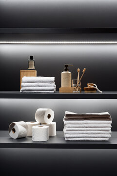 Bathroom shelf with organized towels toilet paper and hygiene supplies