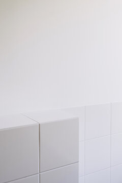 Minimalist white tiled wall in bathroom or kitchen