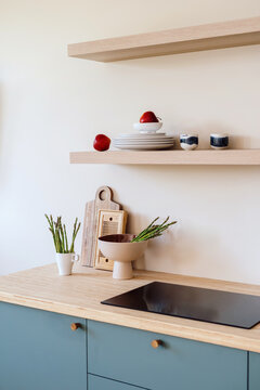 Modern minimalist kitchen with induction hob, dishware and groceries