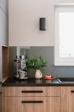 Modern kitchen counter with chrome espresso machine and berry cake