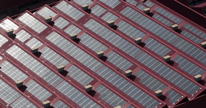 Larderello, Italy - 15 April 2026: Aerial view of solar panels installed on the red industrial roof of the Enel Green Power geothermal plant in Tuscany.