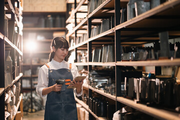 Female worker in storage room with tablet and barcode scanner, checking inventory on shelf © chokniti