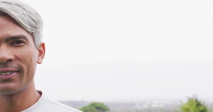 Mature African American man in light shirt on left near treeline, shifting to laughing, copy space