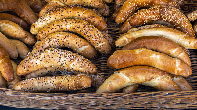 Warn fresh baked wholegrain wheat buns inside rattan basket on bakery counter