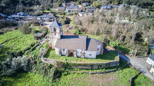 Aerial view of the church of Our Lady of the Assumption, belonging to the parish of San Juan de Paluezas, standing out imposingly on a barbican at the top of the Bierzo village