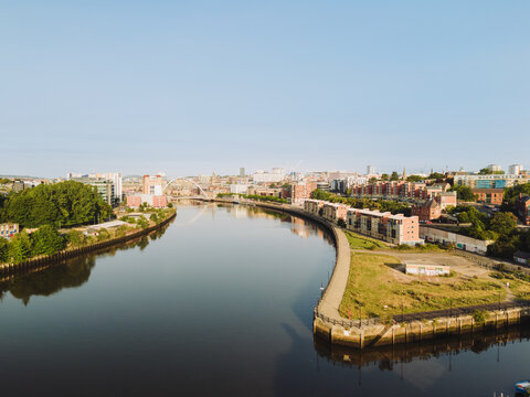 Newcastle upon Tyne: 9th August 2025: Mouth of the Ouseburn joins the River Tyne in Newcastle with buildings and waterfront pathway during clear weather. Drone view