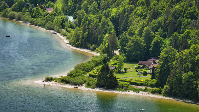 Aerial view of the serene Lac de Joux's shoreline, where emerald waters meet verdant forests and quaint settlements nestle peacefully, Le Lieu, Vaud, Switzerland.