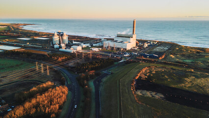 Lynemouth Northumberland: 31st Dec 2025: Lynemouth Power Station stands on a winter morning. The sun rises, casting light on the buildings and nearby coastline © Graeme J Baty