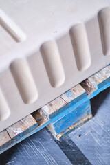 Close up of white moulded plaster decorative trim with stepped profile on wooden surface for interior design and construction detail. Manufacture and construction © dannyburn