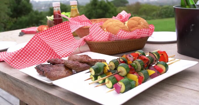 Vertical video: Panning camera moving closer over picnic table, revealing vegetable skewers