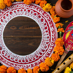 Naklejka premium Traditional Alpona art circle with marigold flowers and flute for Bengali New Year celebration background